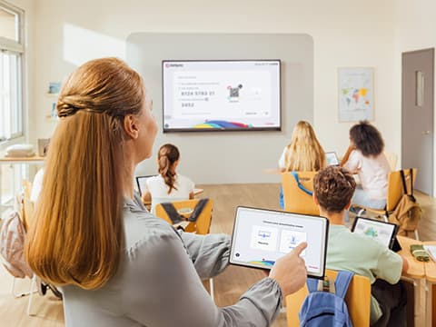 Teacher wirelessly sharing lesson content to a classroom display